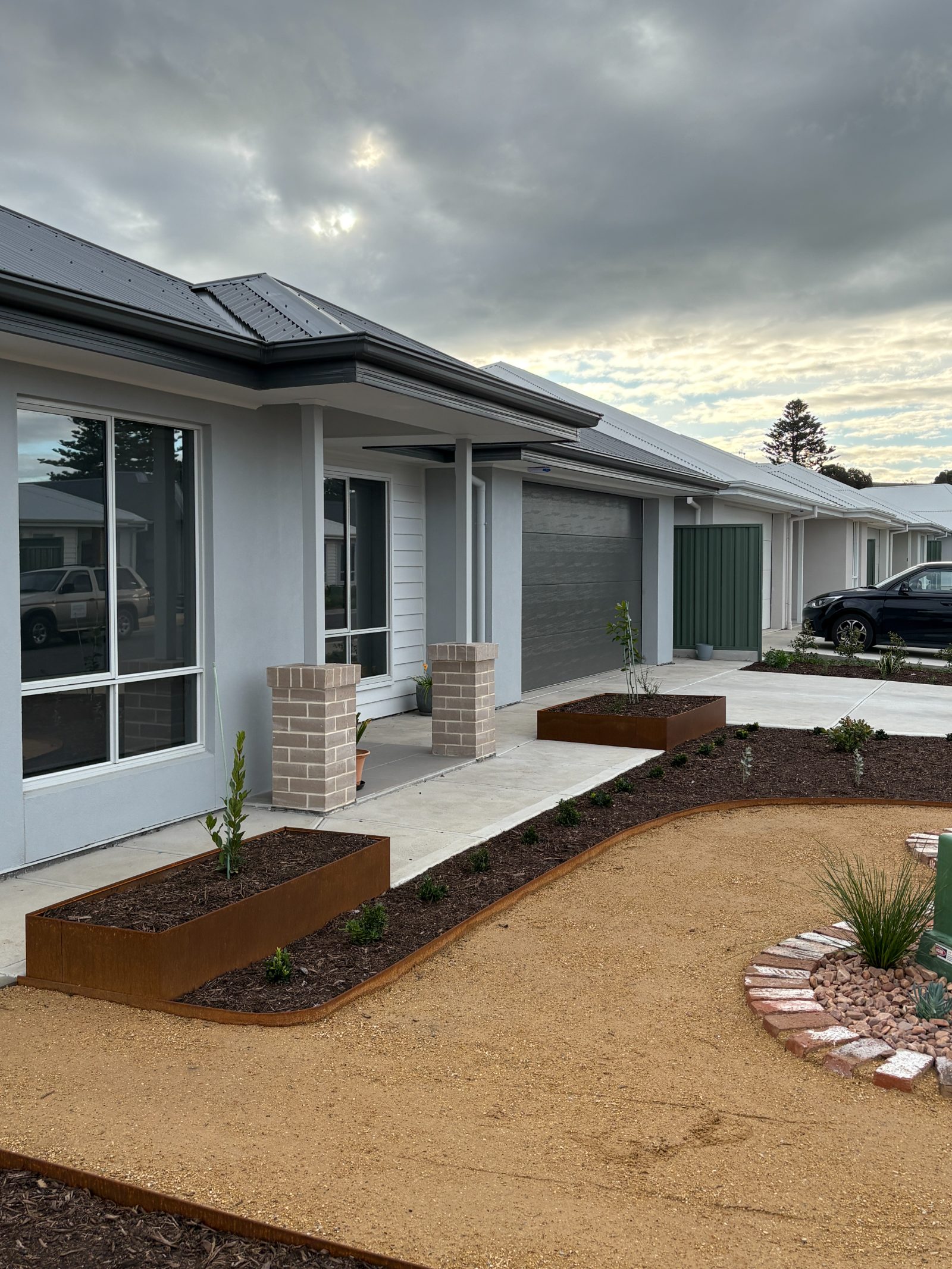 Front garden with corten steel planter boxes, mulched beds and gravel